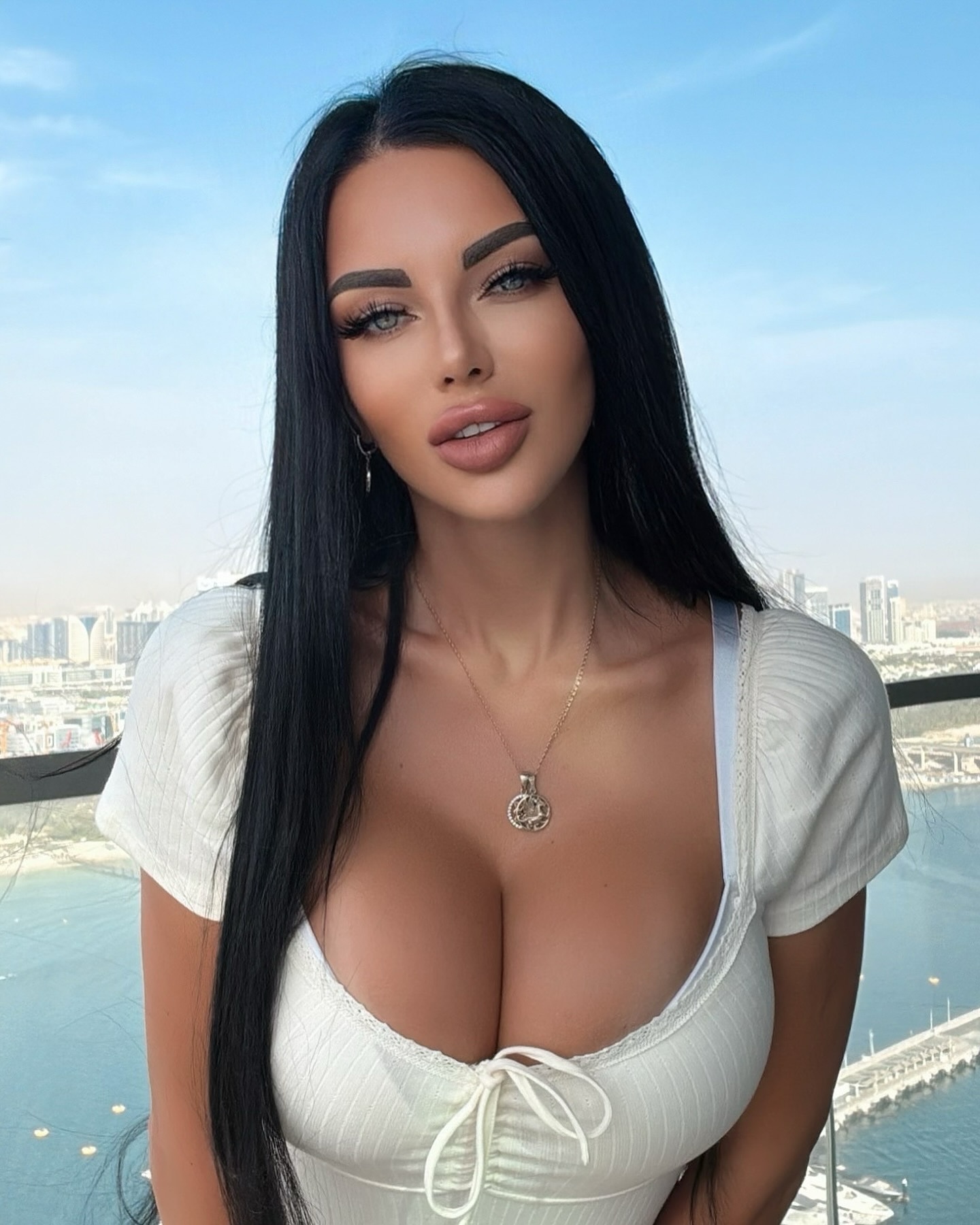 Пыногрудая брюнетка делает фото на фоне города